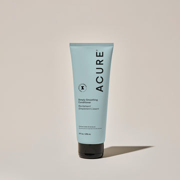 A tube of ACURE Simply Smoothing Conditioner against a neutral background.